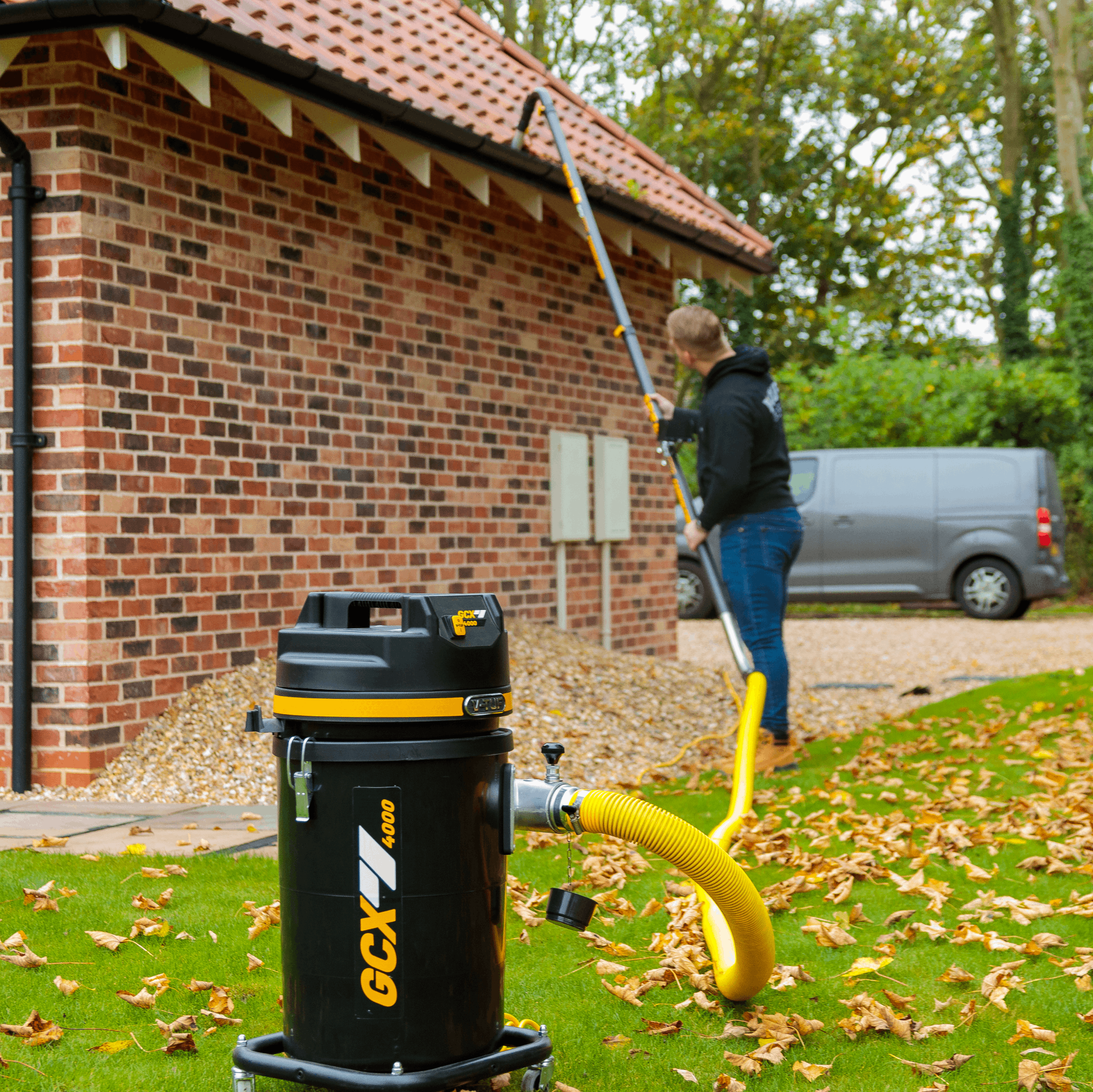 Person cleaning their gutters with a pressure washer